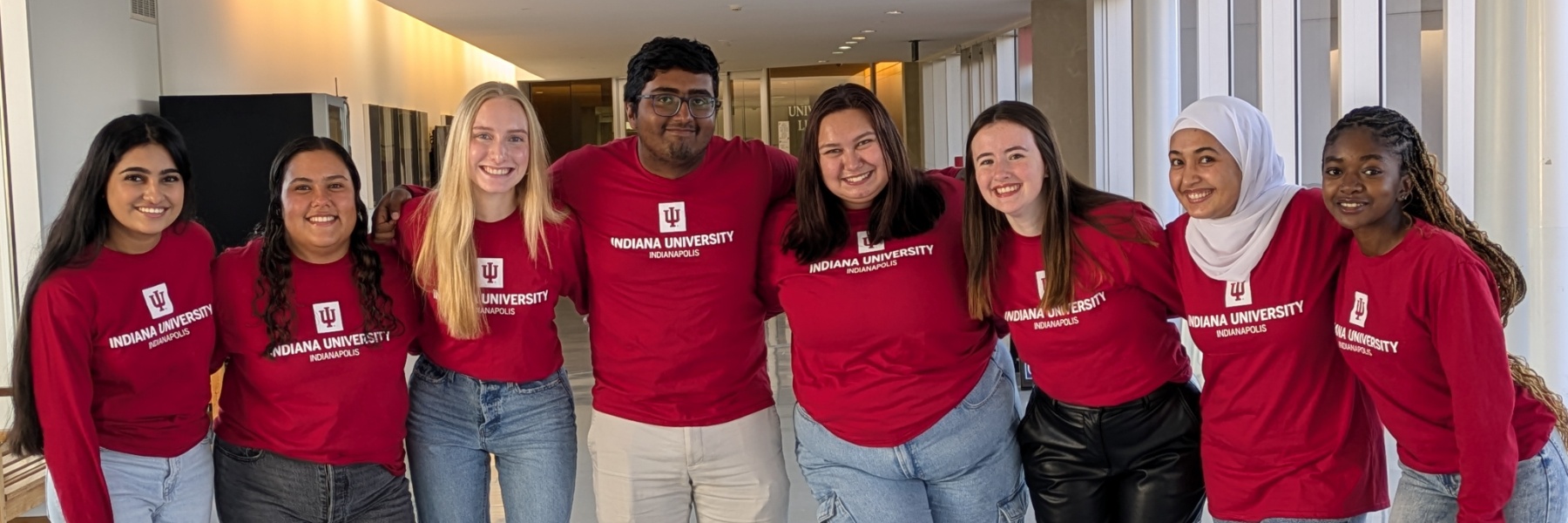 Picture of the 8 Peer Advisor in Academic and Career Development in a line across the University Library Hallway entrance. 